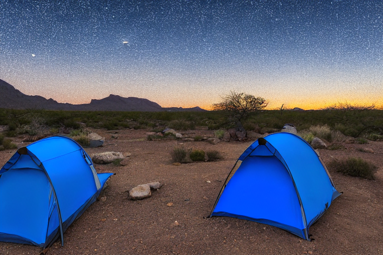 A bright blue tent rests on a quiet paved campsite in Big Bend National Park. Warm sunset light colors the sky, with a pale moon rising in the distance. Stones and a dusty hiking path add a wild, peaceful feel.