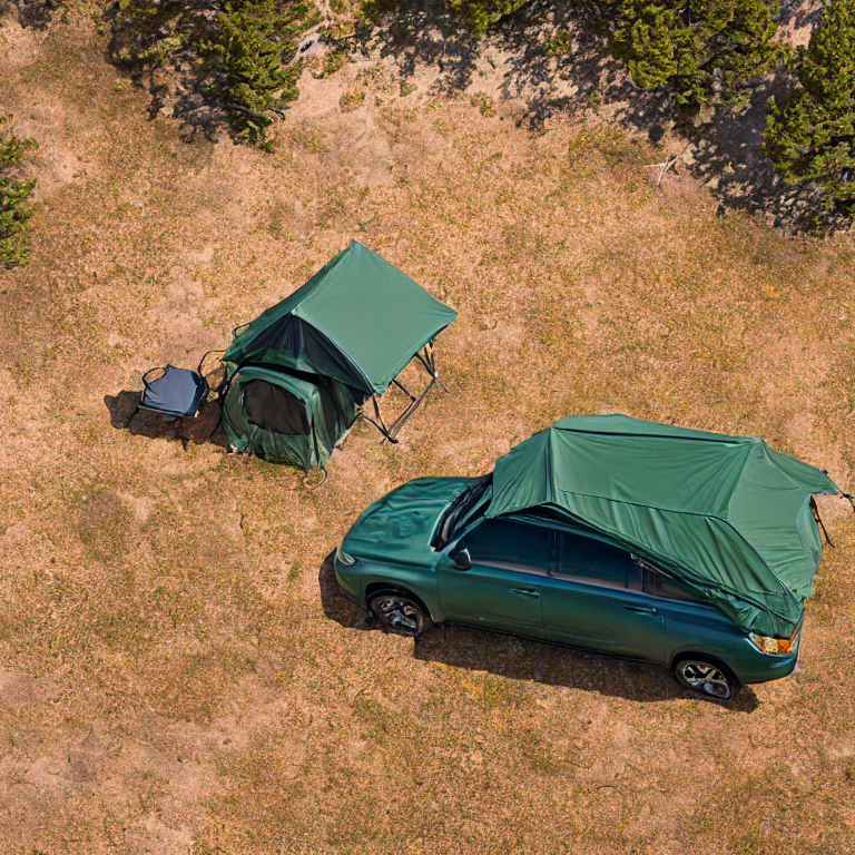A forest green Subaru rests at a quiet campsite beneath a snowy sunset. Its rooftop tent is open beside camping chairs, tall grass, and small trees glowing with fall colors.