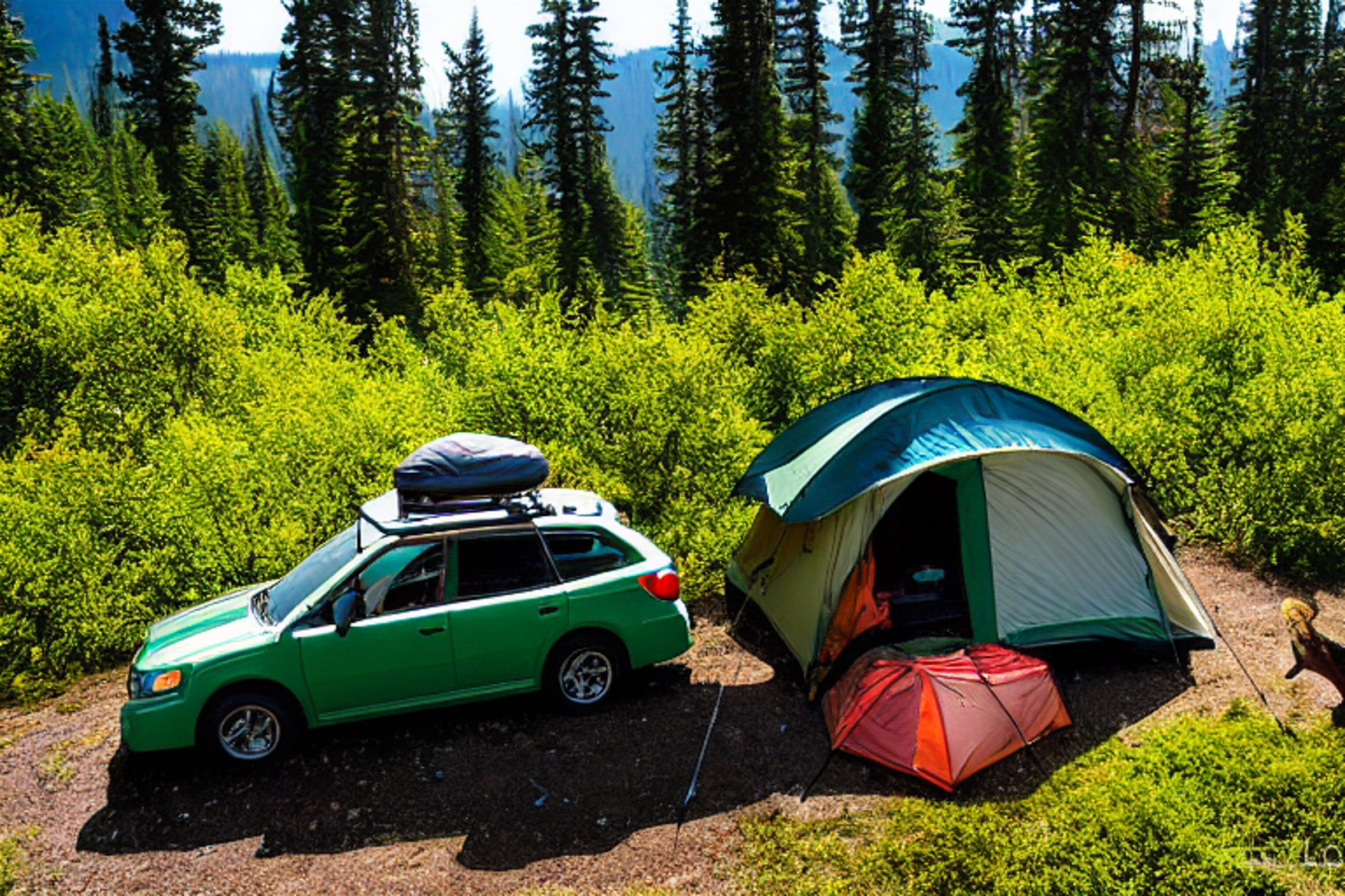 A forest-green Subaru with a rooftop tent rests beside a warm campfire. A clear stream winds through the flower-filled campsite, with rolling hills and a tall mountain glowing under the sunset sky. A backpack sits on the dirt nearby, ready for adventure.
