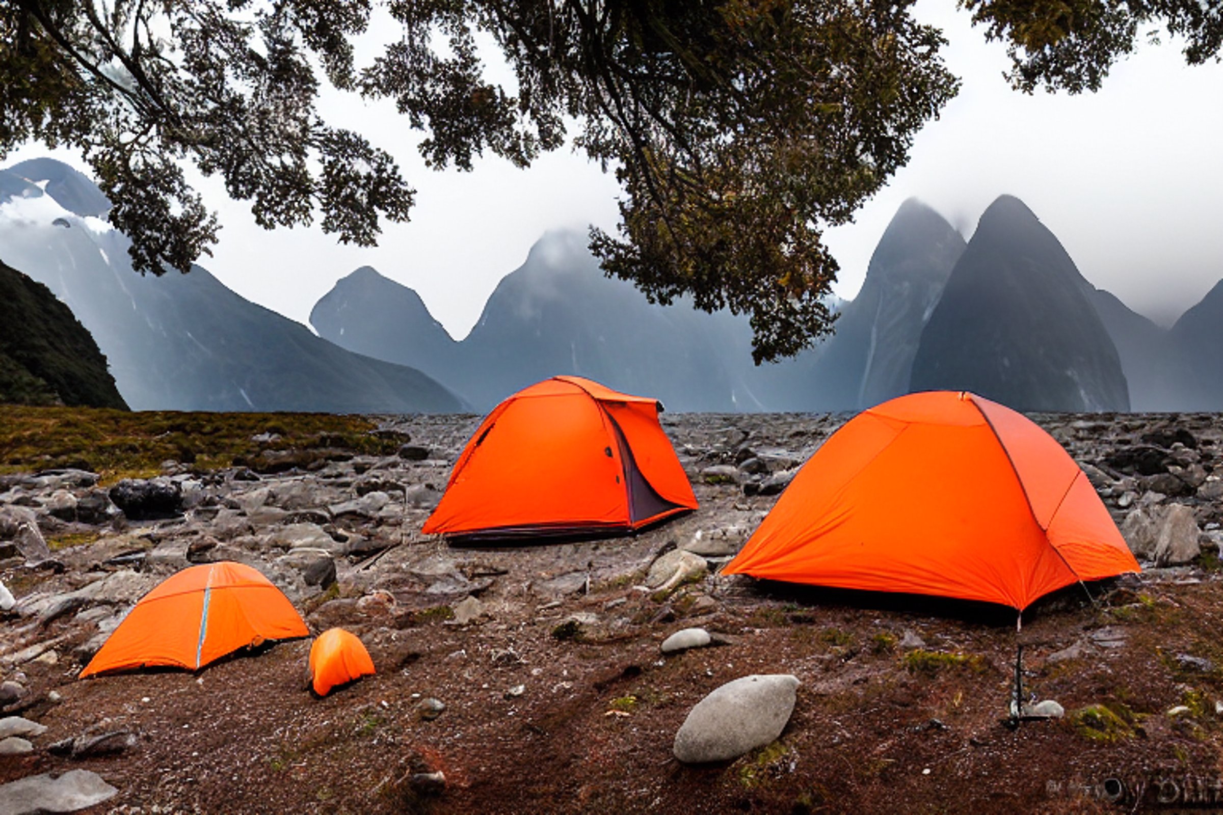 An orange Subaru rests at a quiet dirt campsite in Milford Sound as the sun sets behind the misty mountains. A rooftop tent, camping chairs, lantern, stones, and a wooden guitar create a cozy outdoor scene.