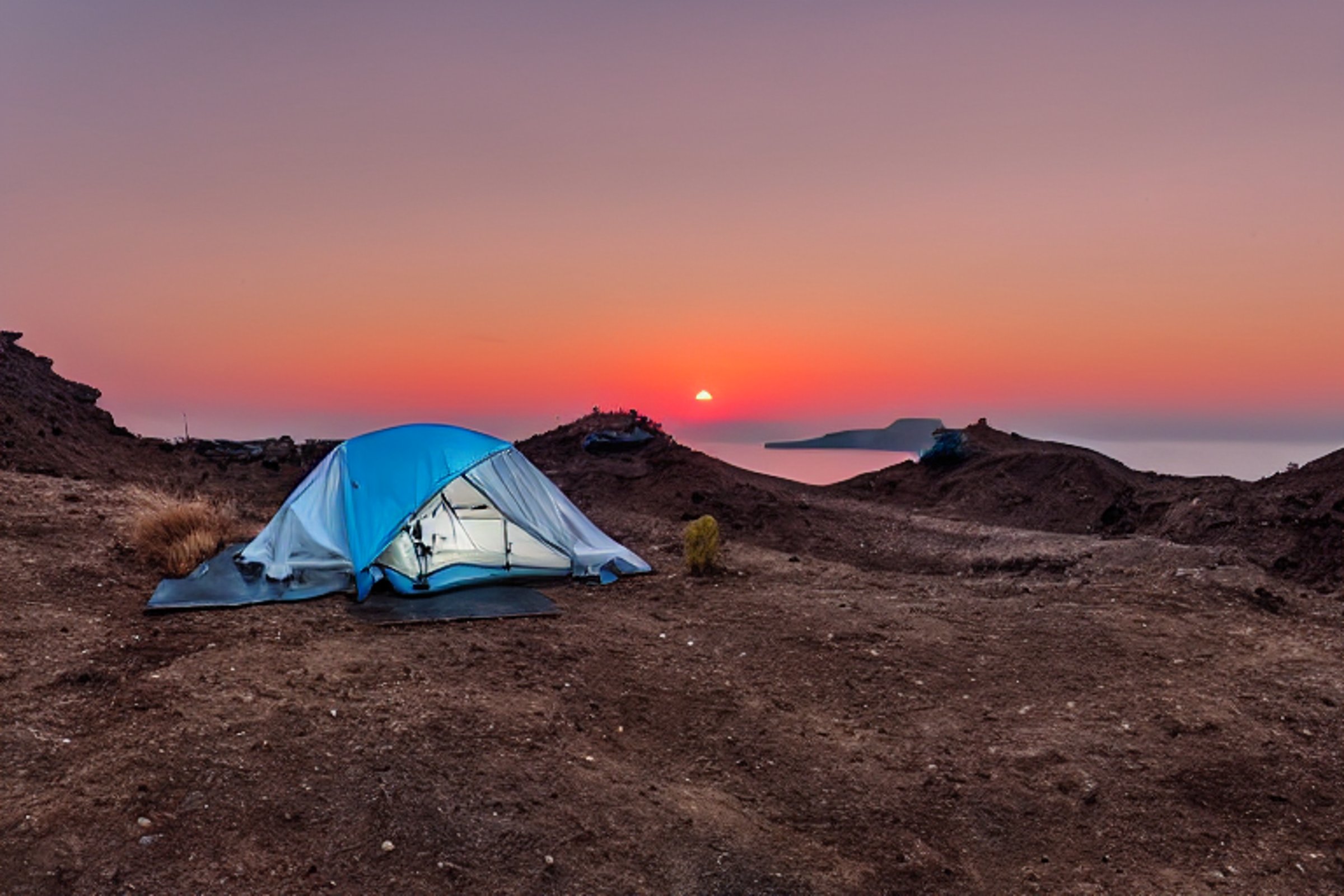 A black tent sits on a paved campsite as the warm Santorini sunset fills the sky. A dirt path winds past a large rock, while a distant camper shines a flashlight.